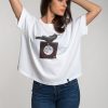 Camiseta blanca de mujer corte murciélago, con imagen de cuervo un posado sobre la luna