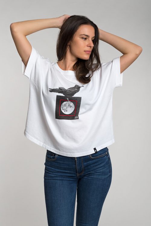 Camiseta blanca de mujer corte murciélago, con imagen de cuervo posado sobre luna